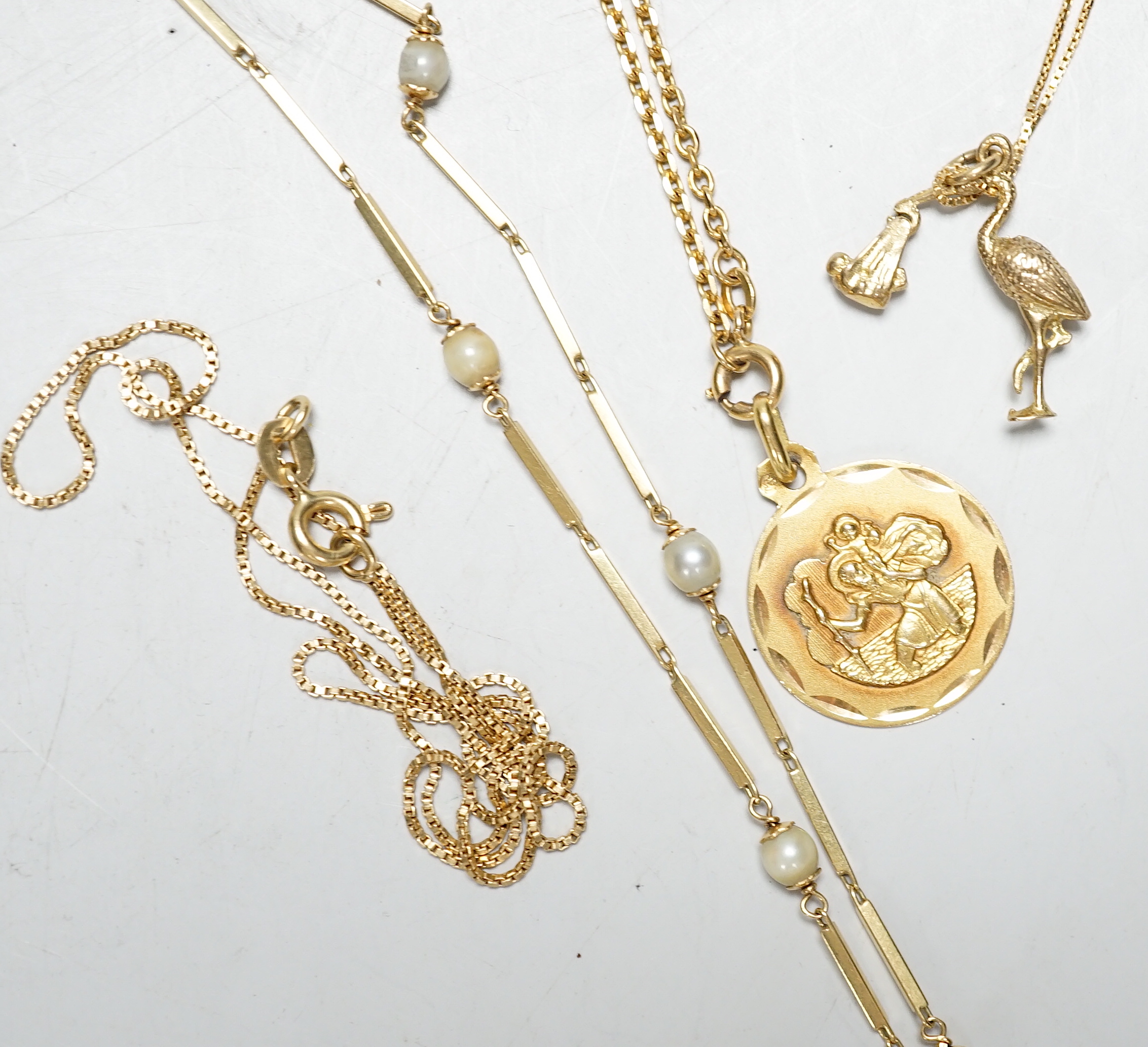 Three assorted modern 750 chains, one with stork charm, the other set with cultured pearls and one other Middle Eastern St. Christopher pendant on chain, longest 72cm